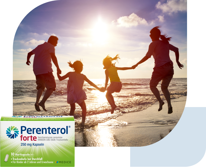 Eine Perenterol forte Verpackung, mit einer spielenden Familie am Strand im Hintergrund