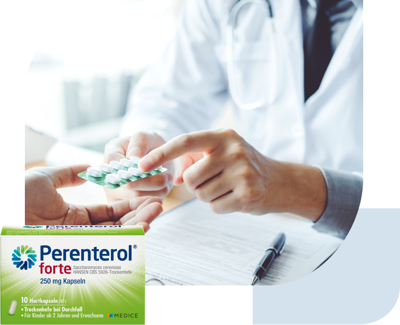 Ärztin überreicht Tablettenblister. Perenterol Packung liegt über dem Bild.